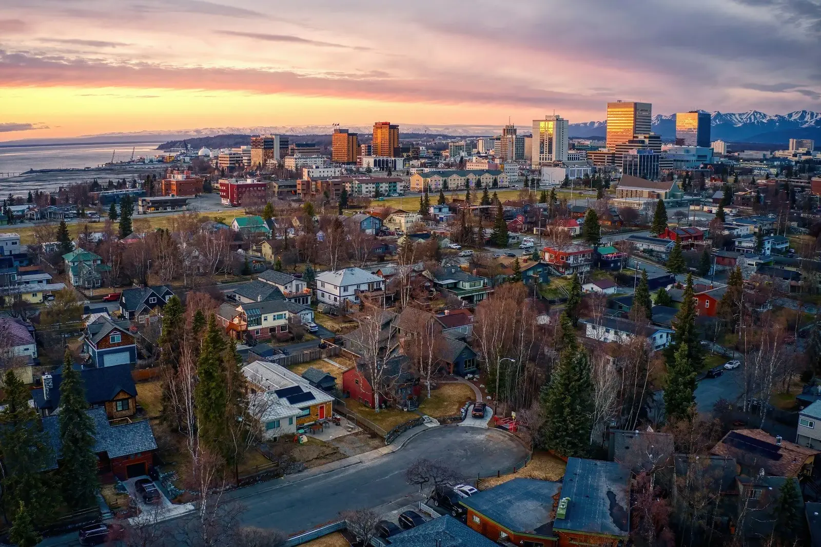 Aerial view of downtown Anchorage, Alaska at sunset with the Chugach Mountains behind the city